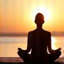 Person meditating in a serene, natural setting